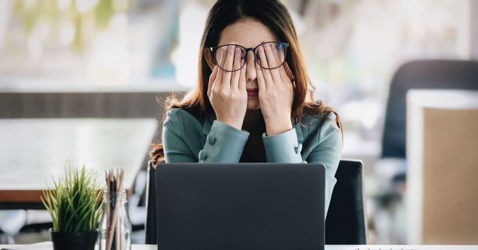 Frustrated female office worker at her laptop