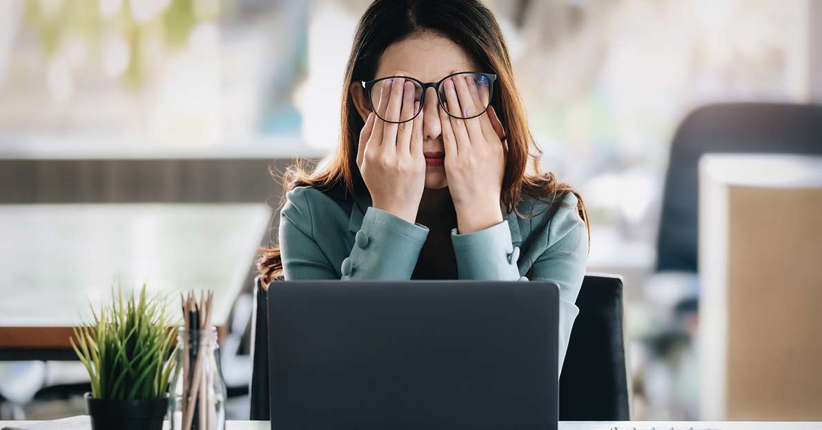 Burnout Syndrome Frustrated female office worker at her laptop